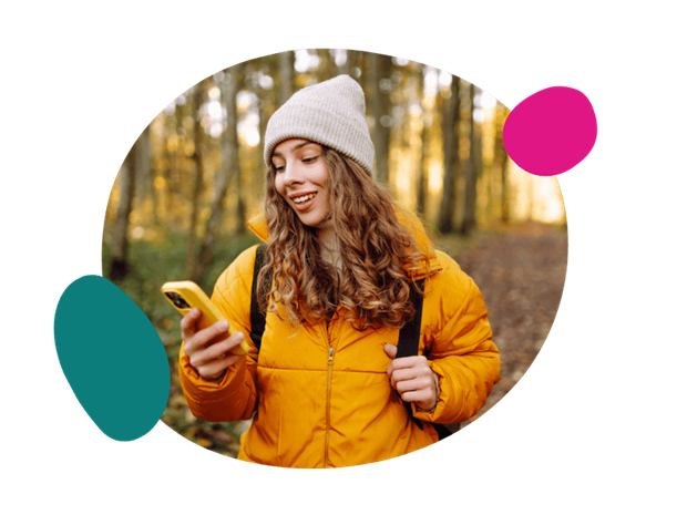woman sat by a tree using her phone