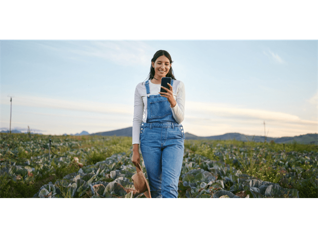 woman walking in a field with her mobile