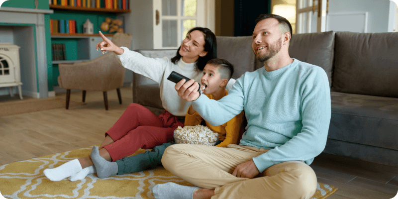 Young family sat watching TV together