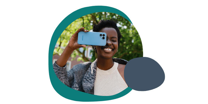 Woman smiling with her Fairphone while taking a photo