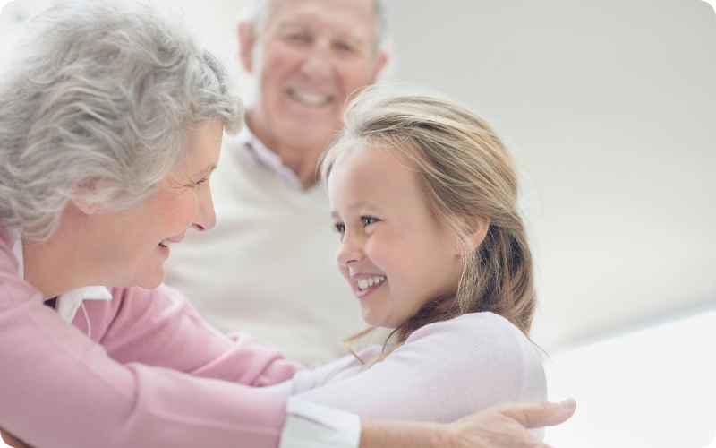 elderly couple playing with their granddaughter