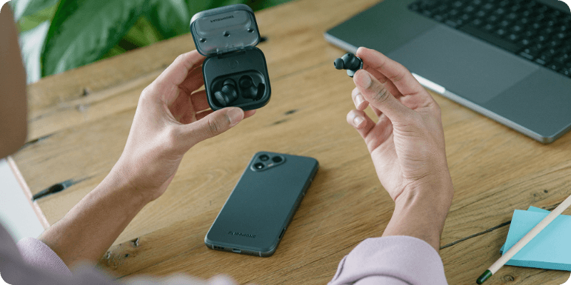 person putting their fairbuds back in the charging case