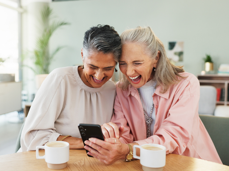 2 friends laughing at their mobile