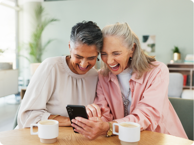 2 friends laughing at their mobile