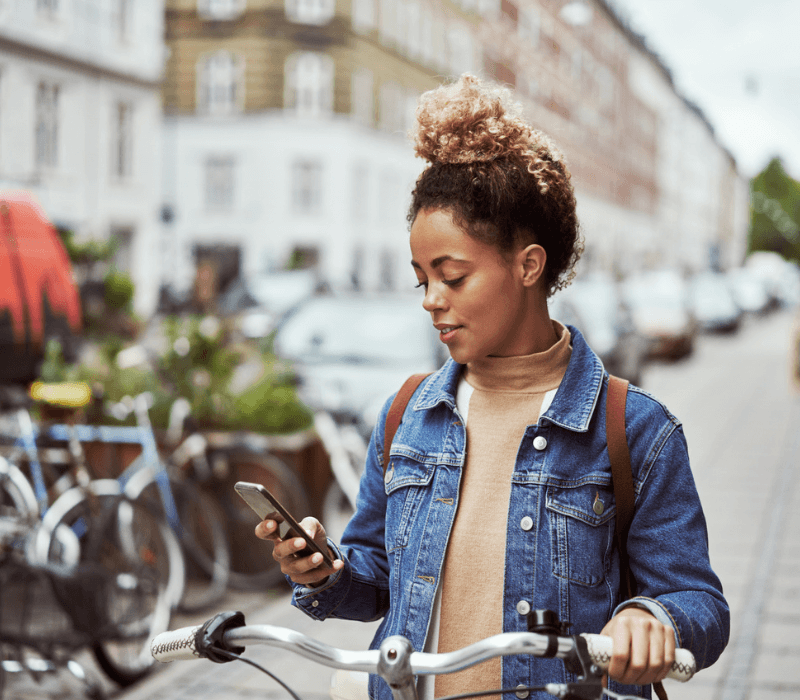 woman using her mobile with her bicycle