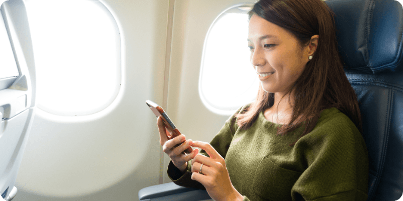 woman using her mobile on a plane