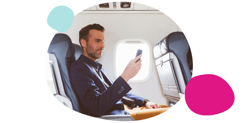 man using his mobile on a plane