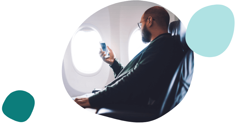 man using his mobile on a plane