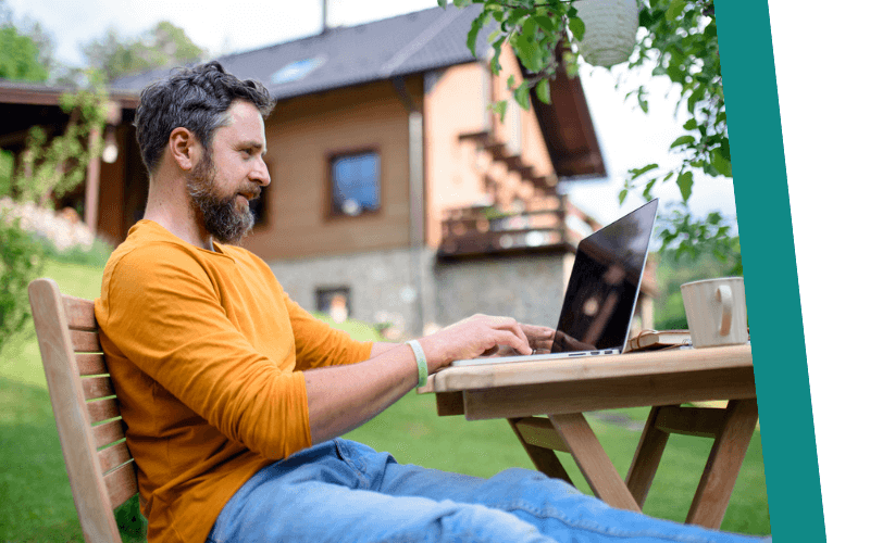 Man sat down using his laptop outside 