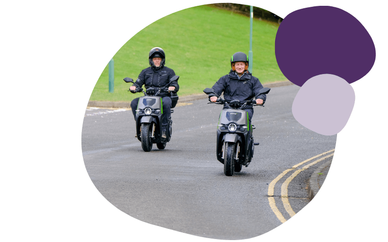 two people riding e-mopeds