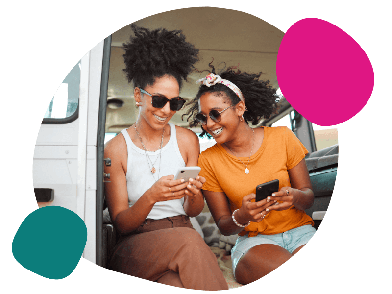 two friends using their mobile on holiday