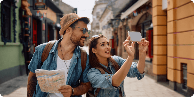 young couple on holiday taking a picture with their phone