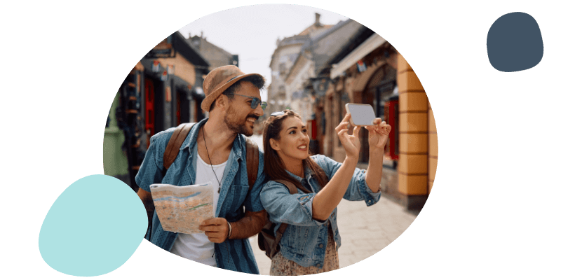 young couple on holiday taking a picture with their phone