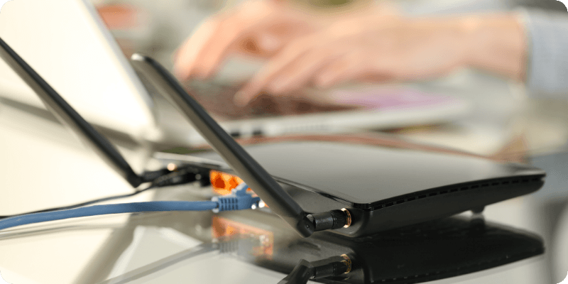 person using their laptop to fix their broadband router