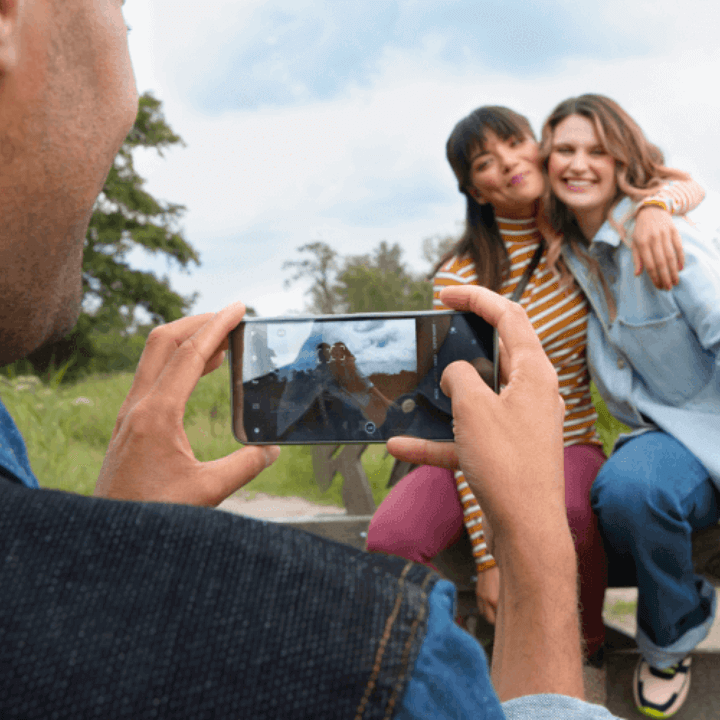 Person taking a photo of 2 women using a Fairphone 4 mobile