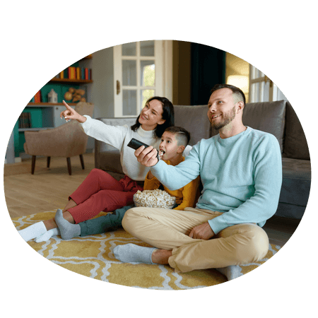 young family sat watching tv together