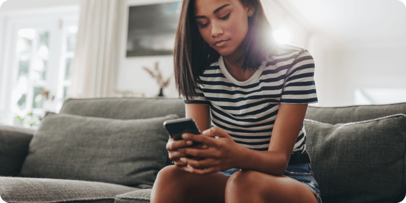 young woman using her phone at home
