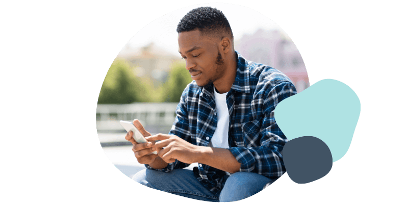 man texting his friends outside