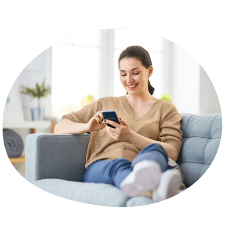 woman sat on her sofa using a mobile
