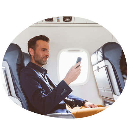 man using his mobile on a plane
