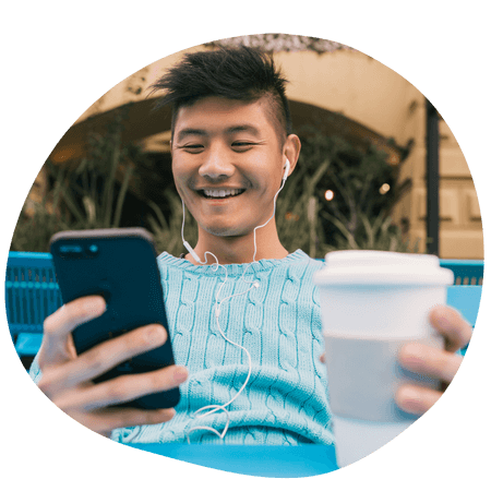 young man texting his friends at a coffee shop