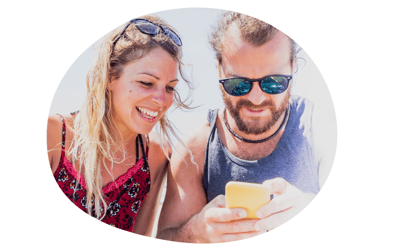 young couple using their mobile together on holiday