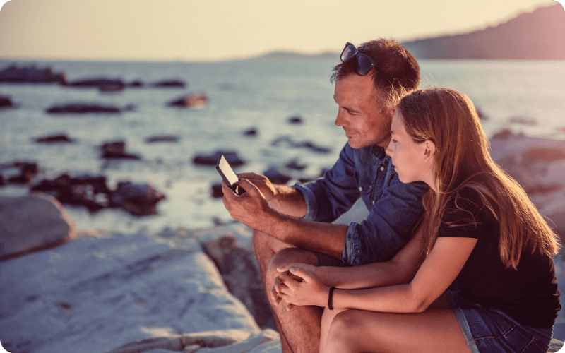 young couple using their mobile together on holiday
