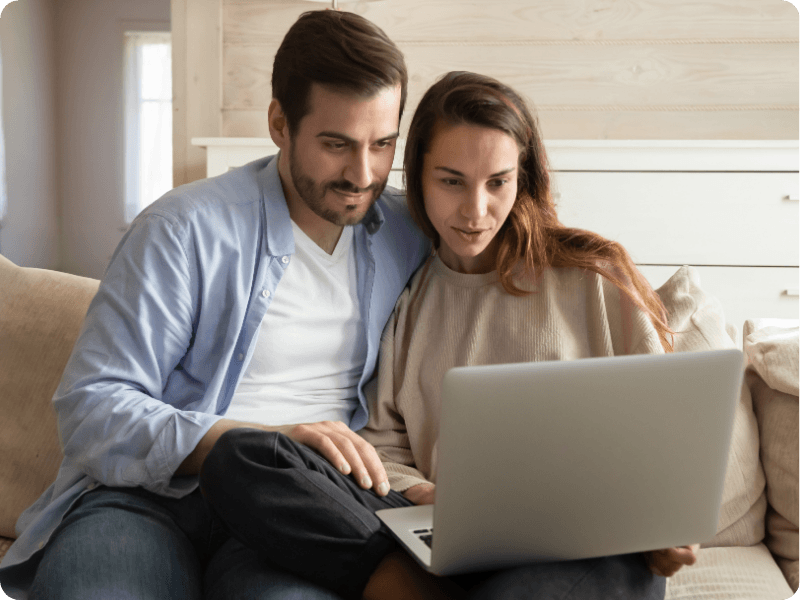 young couple searching the internet on their laptop