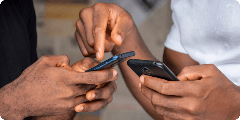 two friends using their mobiles together