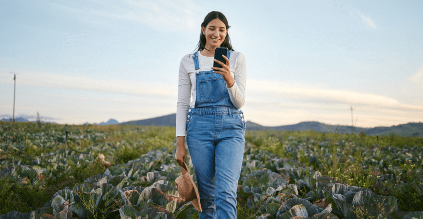 Young woman checking her mobile on a farm