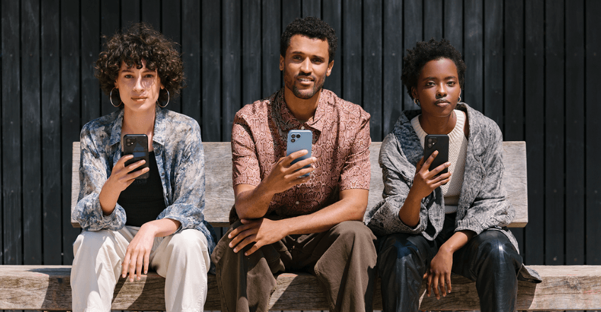 three friends holding up fairphone 5s