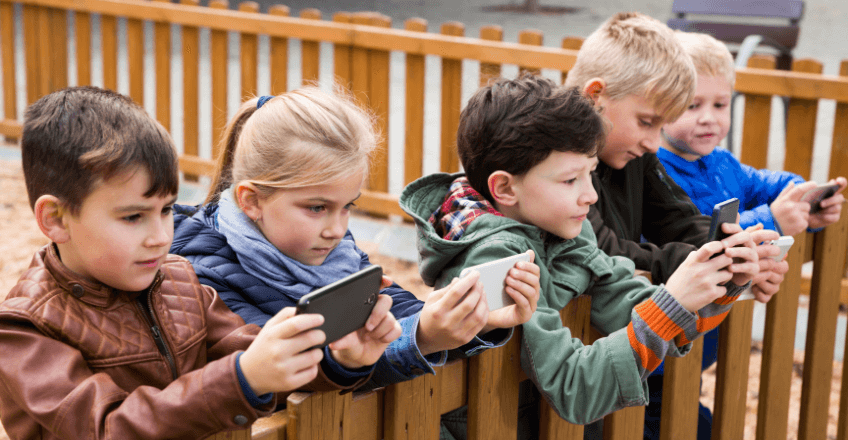 group of children playing on their smartphones