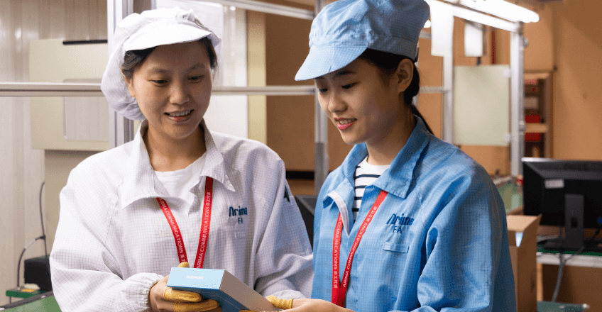Workers in factory making Fairphone holding the smartphone