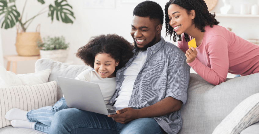 young family sat around a computer