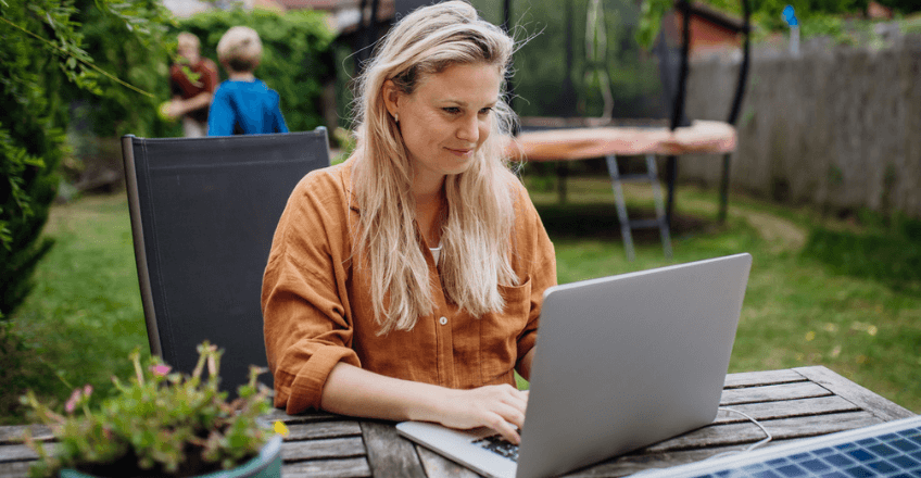 woman working on her computer in a garden