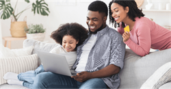 young family sat around a computer