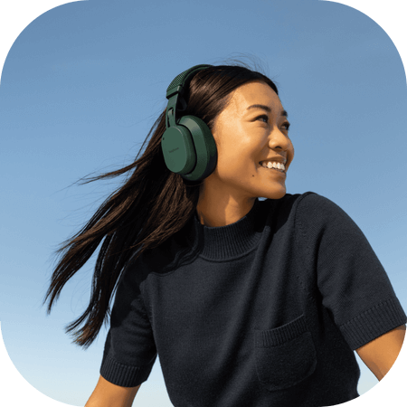 woman wearing green Fairbuds XL headphones outside